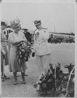 Queen Elizabeth and King George VI admire floral tributes.