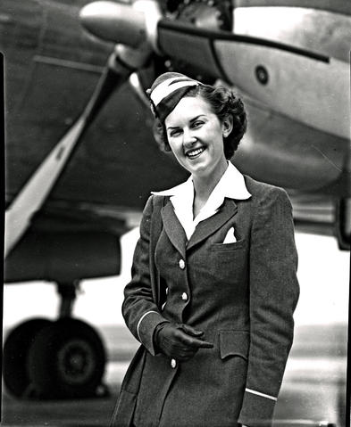 SAA Lockheed Constellation hostess Miss Manchip standing next to engine ...