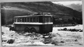 Circa 1930. SAR three-axled bus fording river. Note roof rack at the back.