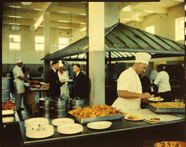 Chef dishing up food in workshop cafeteria.