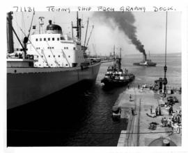 Durban, 1962. Ship being towed from graving dock in Durban Harbour.