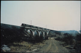 
Five diesel locomotives on concrete arch bridge.

