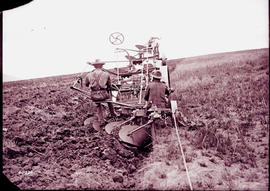 Farmer working a field with animal-drawn plough.