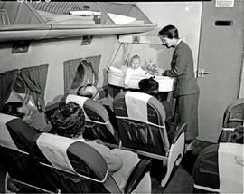 
SAA Douglas DC-4 interior. Hostess at 'Sky cradle' bassinet.
