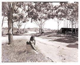 Namibia, 1952. Woman sitting at roadside.