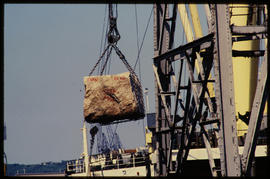 
Large rock lifted by crane.
