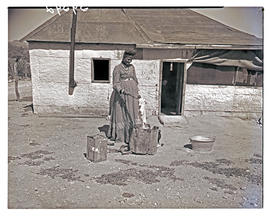 Windhoek, Namibia, 1952. Herero woman boiling clothes in front of home.