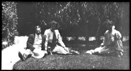 Man and two women having picnic.