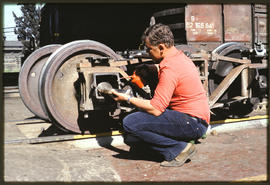 Apprentice oiling train wheel.