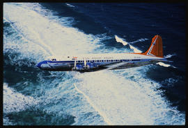 SAA Douglas DC-4 ZS-AUB 'Outeniqua' in flight over water.