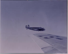 
Palmietfontein, 1952. SAA Lockheed Lodestar ZS-ASU 'Piet Retief' in flight over wing of another ...
