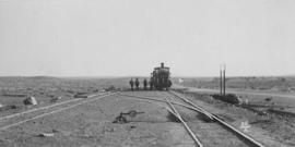 Swarts, 1895. Cape 3rd Class 'Four-coupled Joys' locomotive with four men posing in the distance....