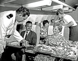 
SAA Boeing 707 interior. Serving meal. Steward and hostess.
