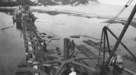 Wilderness, circa 1926. Wilderness bridge construction: Screwing steel pile for permanent bridge....