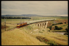 Balfour district, 1974. Drakensberg passenger train on concrete arch bridge.